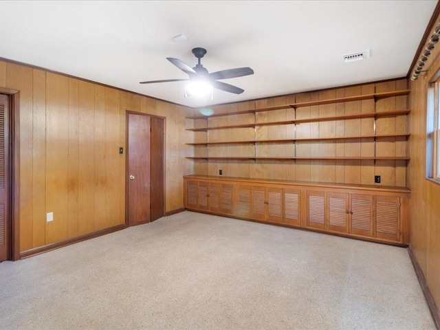 spare room featuring ceiling fan and wooden walls