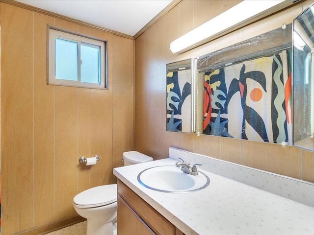 bathroom featuring walk in shower, crown molding, toilet, wooden walls, and vanity