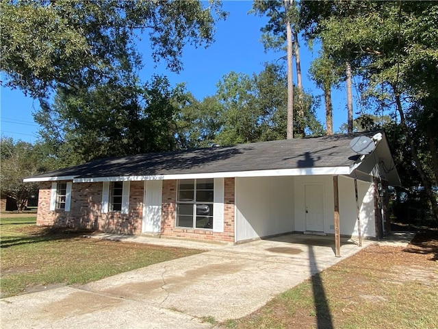 ranch-style home featuring a front lawn and a carport