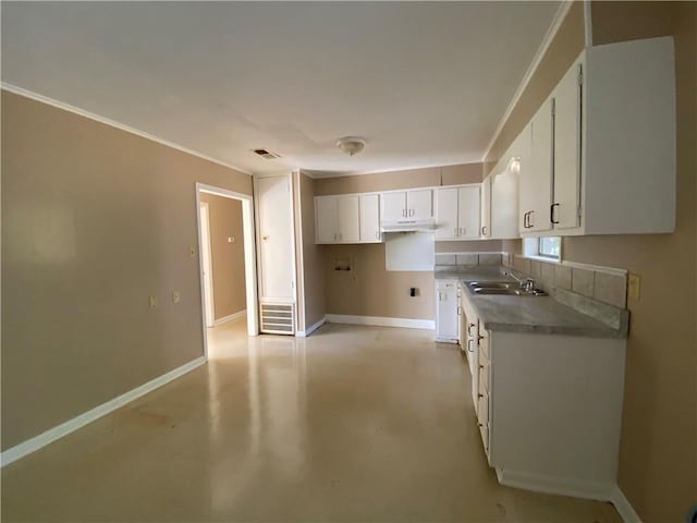 kitchen featuring white cabinets, ornamental molding, and sink