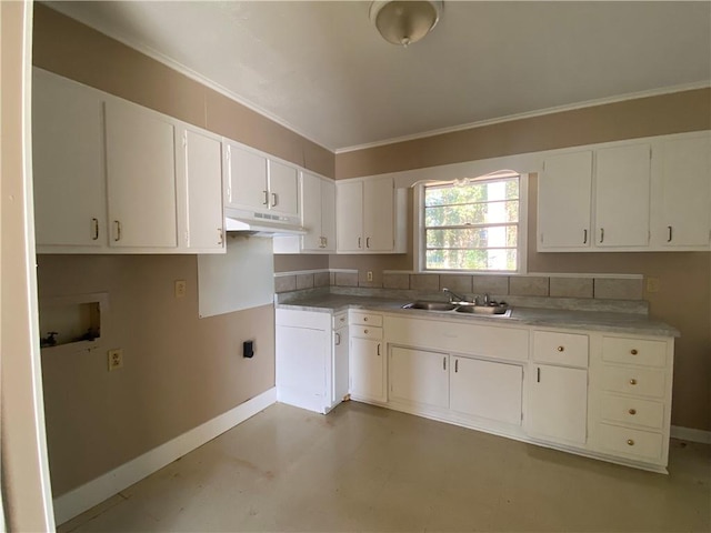 kitchen with white cabinets, ornamental molding, and sink