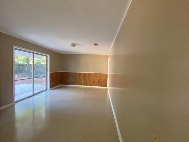 empty room featuring wooden walls and concrete floors