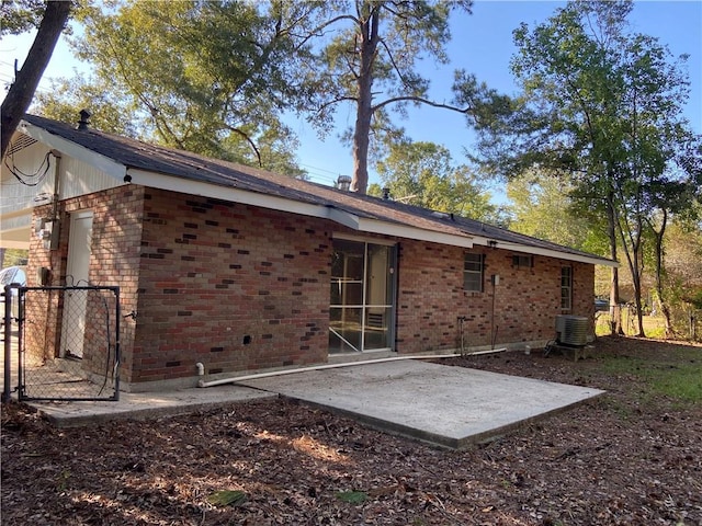 rear view of house with central air condition unit and a patio area