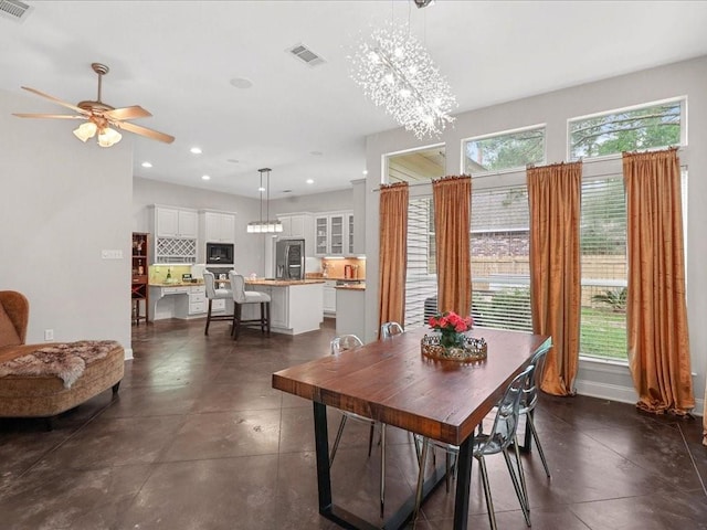 dining area featuring ceiling fan with notable chandelier