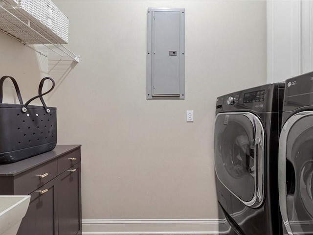 laundry room with electric panel, separate washer and dryer, and cabinets