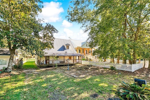 rear view of property featuring a lawn and a wooden deck