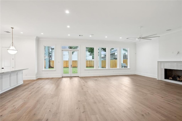 unfurnished living room with light wood-type flooring, ceiling fan, and ornamental molding