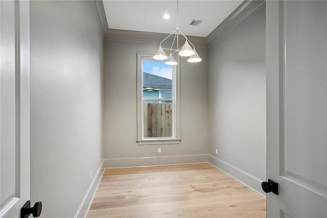 unfurnished room with crown molding and light hardwood / wood-style floors