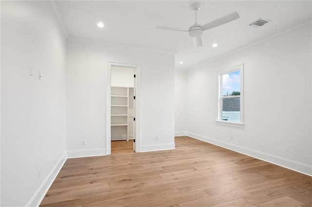 empty room featuring ceiling fan, light wood-type flooring, and ornamental molding