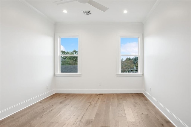 empty room featuring light hardwood / wood-style floors, crown molding, and a wealth of natural light