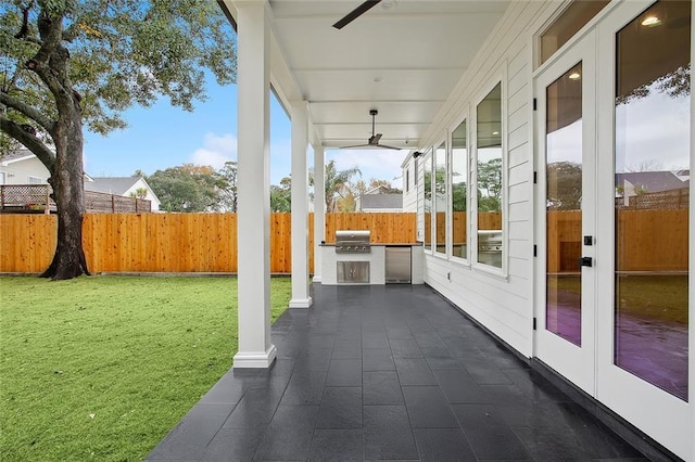 view of patio featuring ceiling fan, area for grilling, exterior kitchen, and french doors