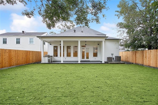 rear view of house featuring a lawn, ceiling fan, french doors, and cooling unit