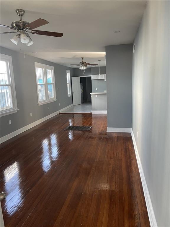 unfurnished living room featuring ceiling fan, dark hardwood / wood-style flooring, and a wealth of natural light