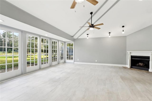 unfurnished living room with ceiling fan, a healthy amount of sunlight, high vaulted ceiling, and light hardwood / wood-style flooring