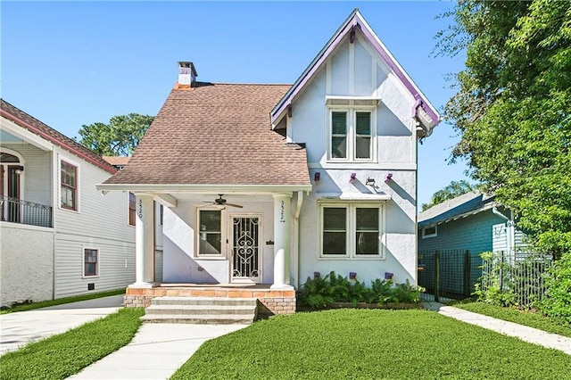 352022 Upperline St, New Orleans, LA 70125 - view of front of home featuring stucco siding, a chimney, a shingled roof, ceiling fan, and covered porch