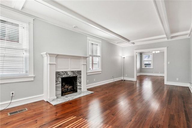 unfurnished living room with beam ceiling, a premium fireplace, and dark hardwood / wood-style floors