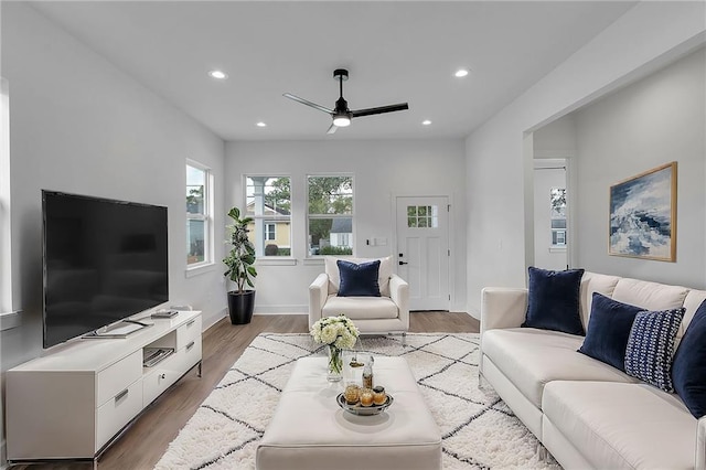 living room with light hardwood / wood-style flooring and ceiling fan