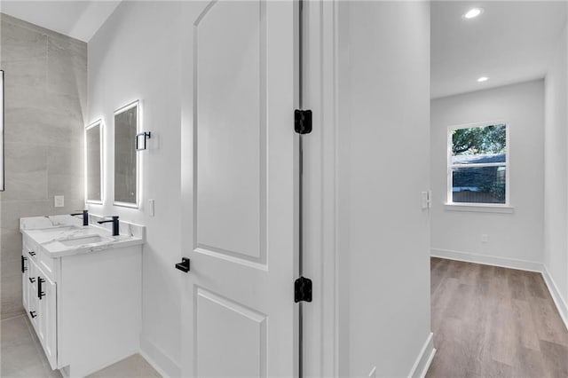 bathroom featuring vanity, hardwood / wood-style flooring, and tile walls