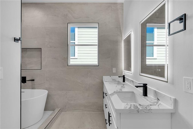 bathroom featuring plenty of natural light, a tub to relax in, and vanity