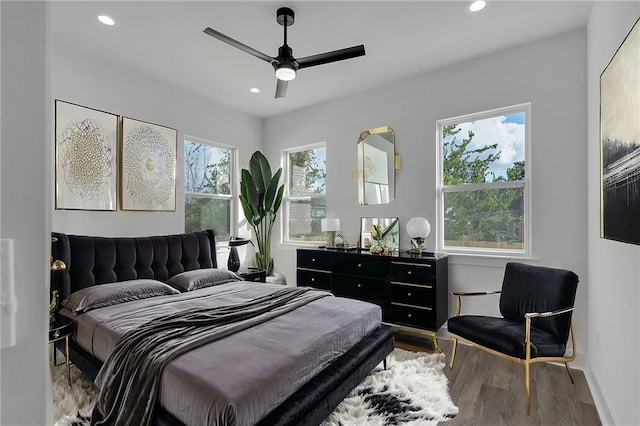 bedroom featuring hardwood / wood-style floors, multiple windows, and ceiling fan