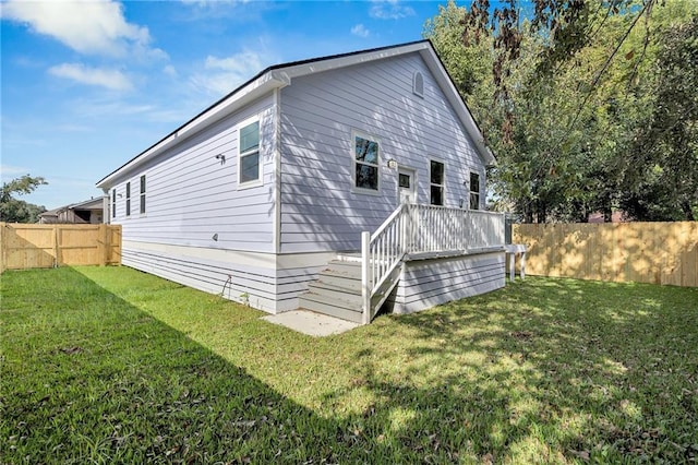 rear view of property featuring a lawn and a wooden deck