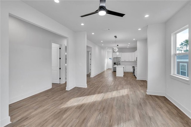 4313 Randolph Ave, New Orleans, LA 70122 - unfurnished living room featuring baseboards, wood finished floors, a sink, and recessed lighting