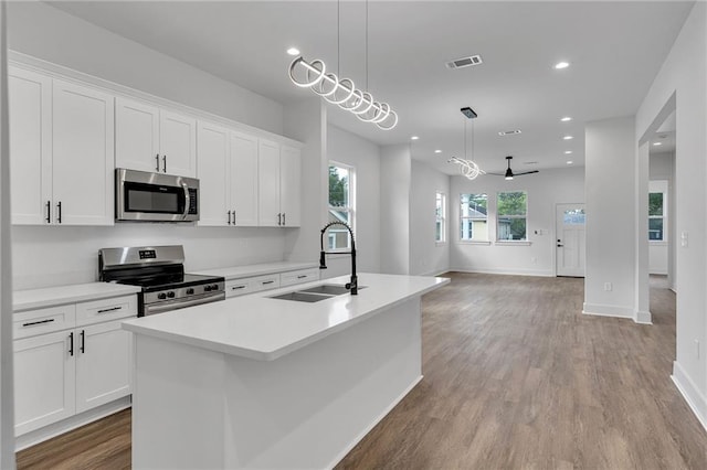 4313 Randolph Ave, New Orleans, LA 70122 - kitchen with appliances with stainless steel finishes, a sink, a center island with sink, white cabinets, and recessed lighting