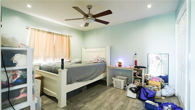 bedroom with hardwood / wood-style floors, a closet, and ceiling fan