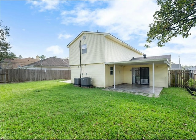 rear view of house with a yard, cooling unit, and a patio