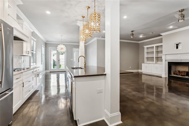 kitchen with sink, white cabinetry, hanging light fixtures, built in shelves, and appliances with stainless steel finishes