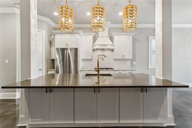 kitchen with decorative light fixtures, white cabinets, stainless steel fridge, and custom exhaust hood