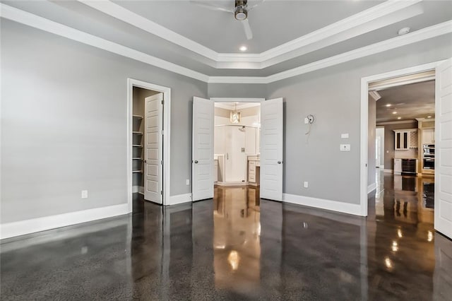 bedroom with a spacious closet, a raised ceiling, ceiling fan, and crown molding