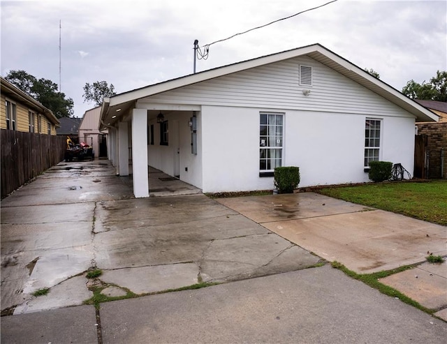 rear view of property with a yard and a carport