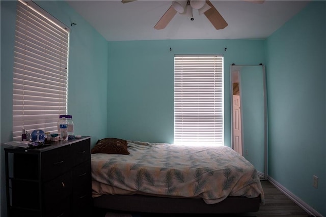 bedroom featuring multiple windows, hardwood / wood-style flooring, and ceiling fan