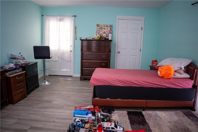 bedroom with vaulted ceiling and light hardwood / wood-style flooring