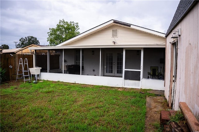 back of house with a lawn and a sunroom