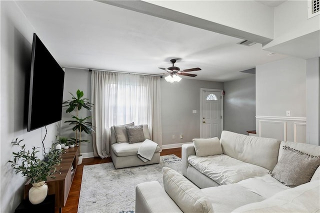 living room featuring dark hardwood / wood-style floors, ceiling fan, and a wealth of natural light