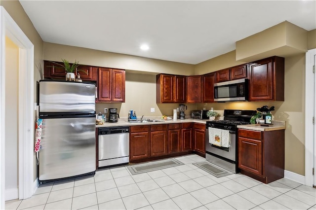 kitchen with sink, light tile patterned floors, and stainless steel appliances