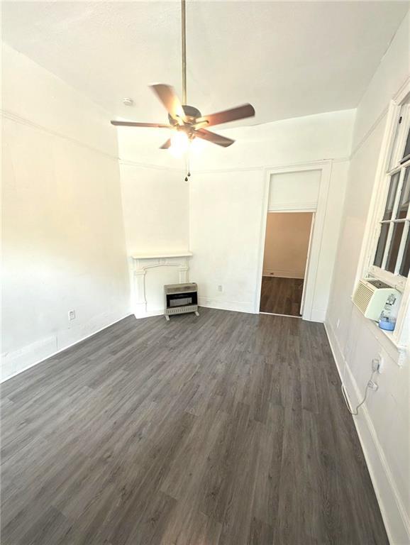 unfurnished living room with dark hardwood / wood-style flooring, cooling unit, and ceiling fan