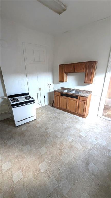 kitchen with white range with gas stovetop and sink