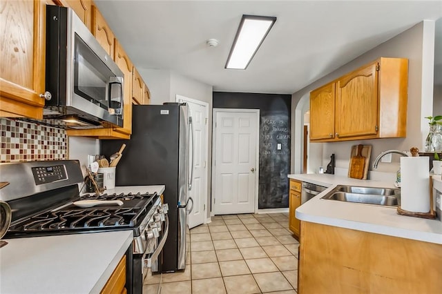 kitchen featuring backsplash, sink, light tile patterned floors, and stainless steel appliances