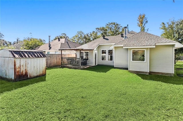 back of house with a yard, a shed, and a deck