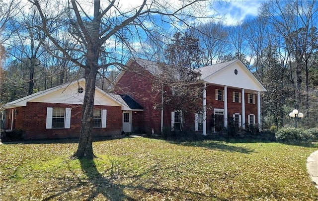 neoclassical / greek revival house with a front yard and brick siding