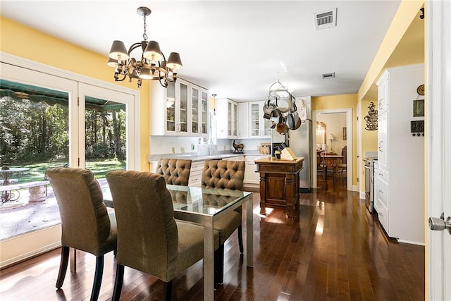 dining room with dark wood-style floors, visible vents, and a chandelier