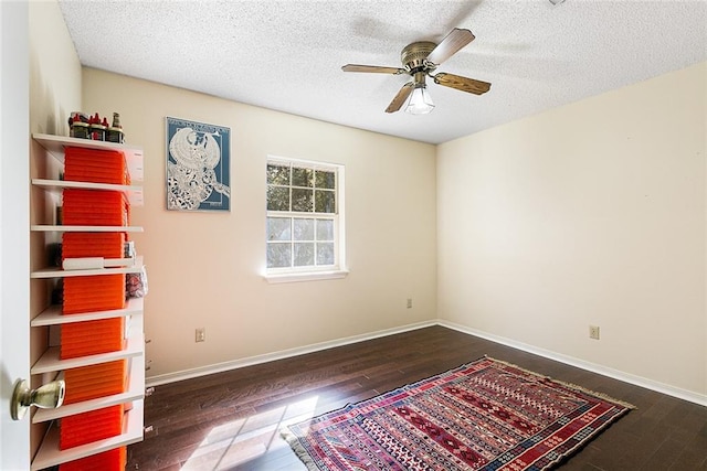 interior space featuring ceiling fan, wood-type flooring, and baseboards