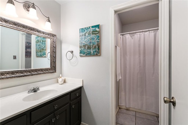 bathroom featuring tile patterned flooring, vanity, and curtained shower