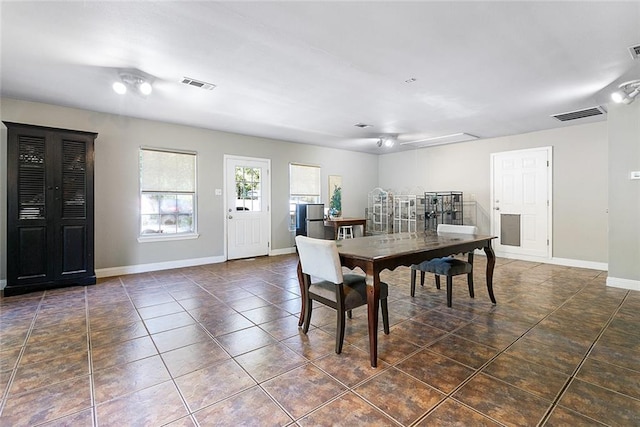 tiled dining space with visible vents and baseboards