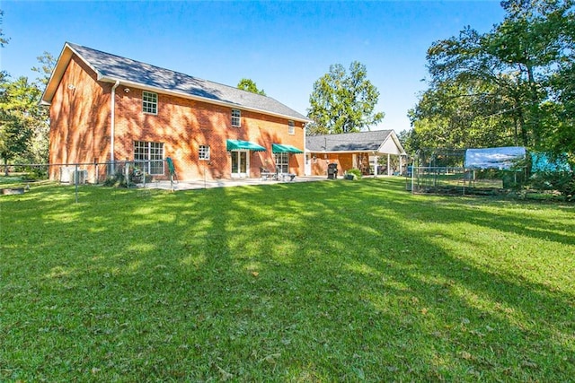 rear view of property with a patio area, brick siding, fence, and a lawn