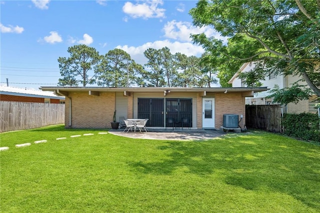 rear view of property featuring a lawn, a patio area, and cooling unit