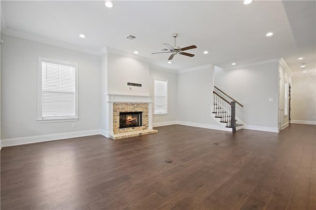 unfurnished living room with dark hardwood / wood-style floors, a brick fireplace, ceiling fan, and crown molding